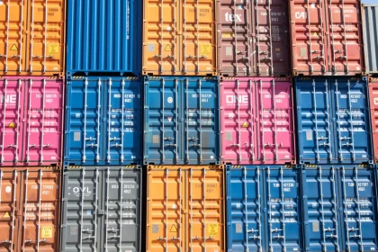 Shipping containers and goods at a border crossing checkpoint symbolizing trade tariffs and customs