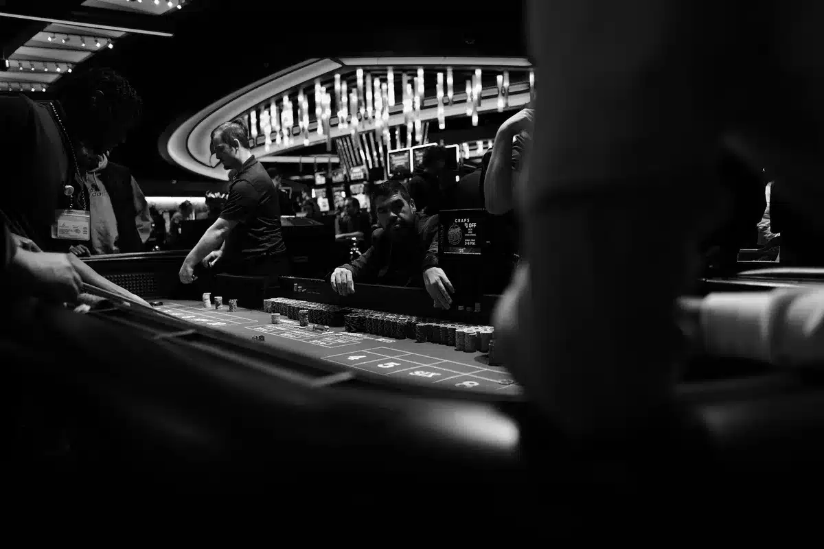 Pokerbord met hoge inzetten, speelkaarten en stapels fiches onder felle verlichting