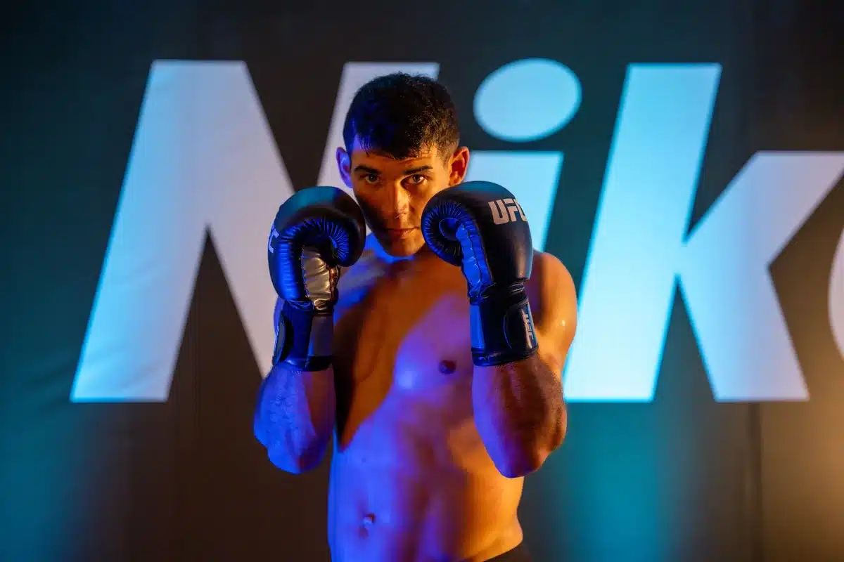 Elite fighter holding championship belts from multiple weight classes