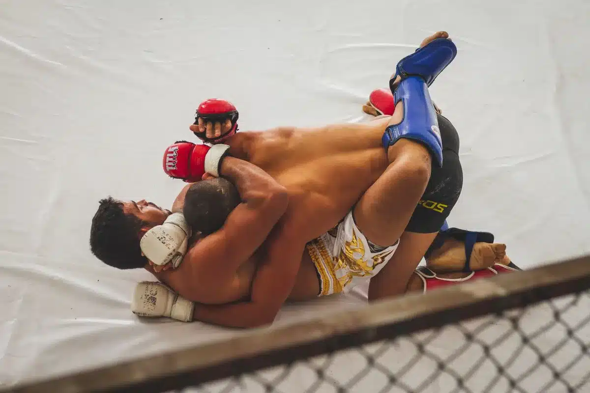 Fighter in dominant grappling position controlling opponent on mat