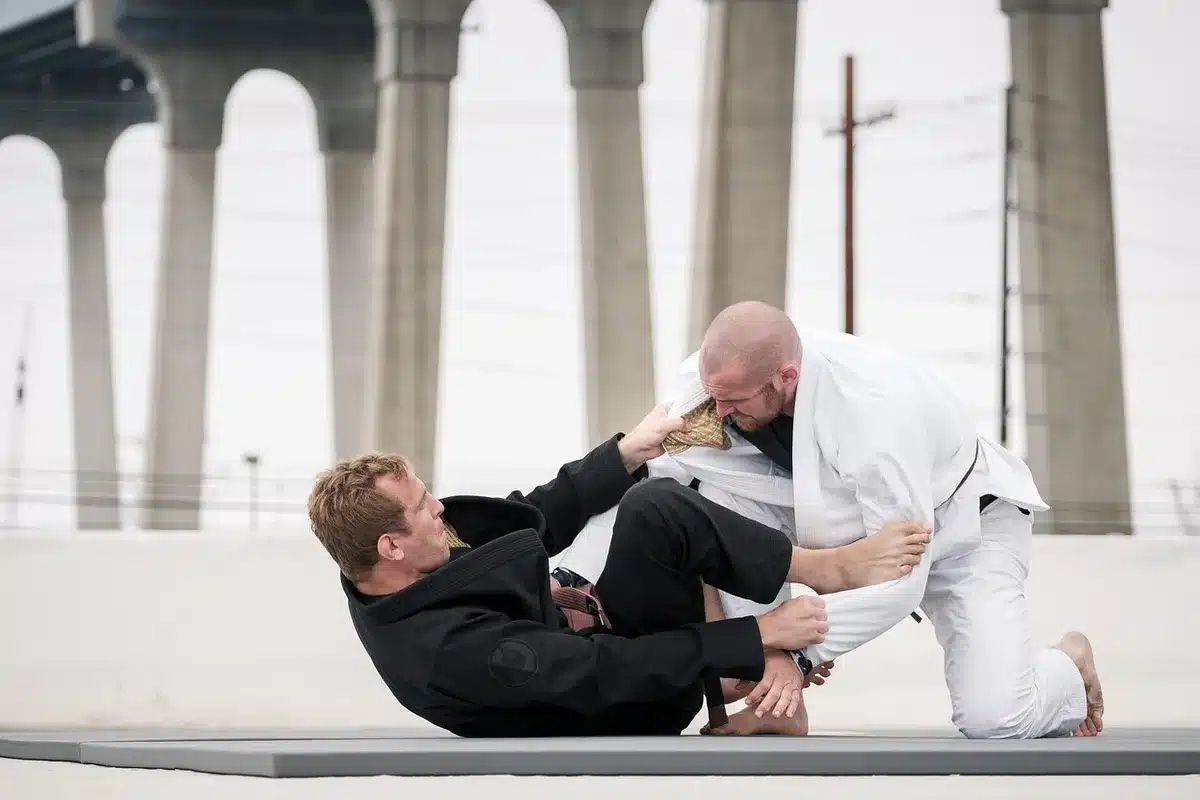 Two MMA fighters grappling in wrestling hold during match