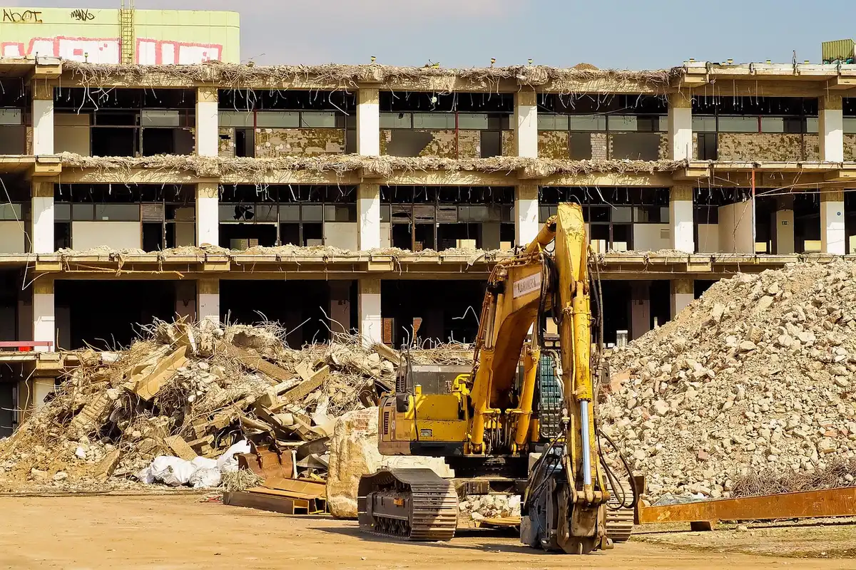 Heavy machinery clearing debris from vacant lot during demolition