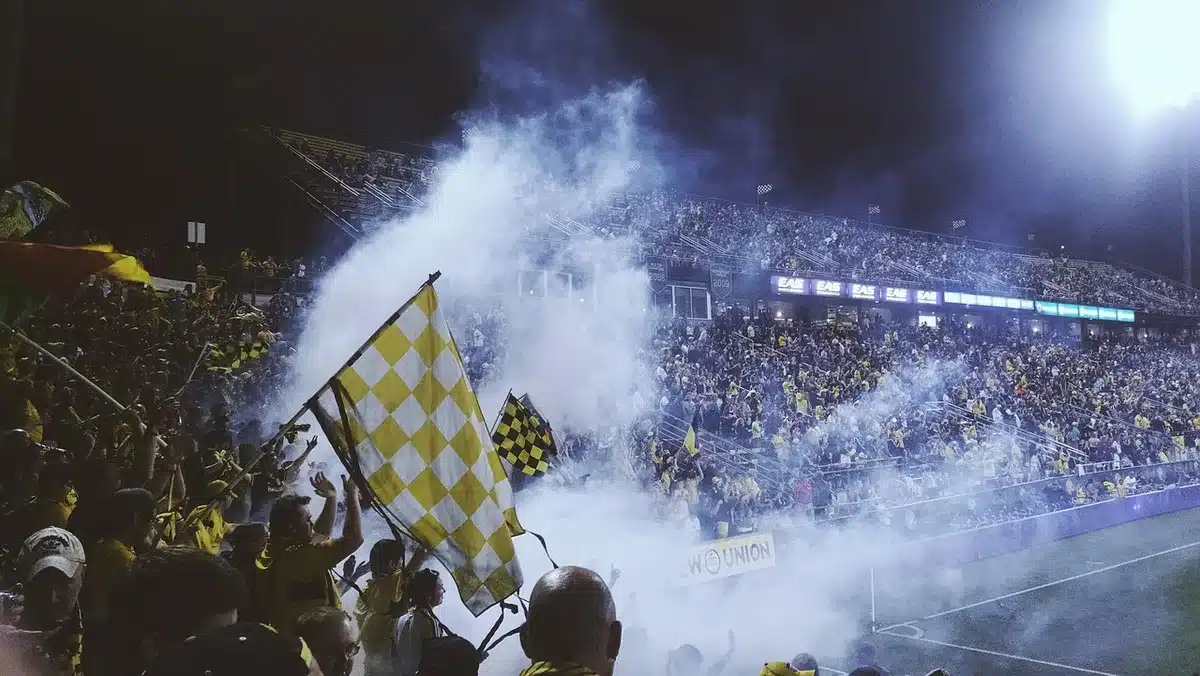 Crowded college football stadium at night during game