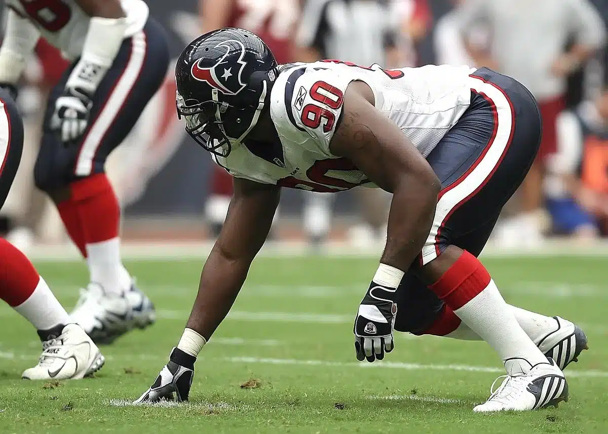 Defensive end sitting on sideline with knee wrap during a game