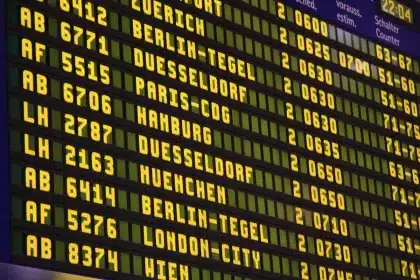 Concourse at an airport with team bags and a departures board, evocative of long travel