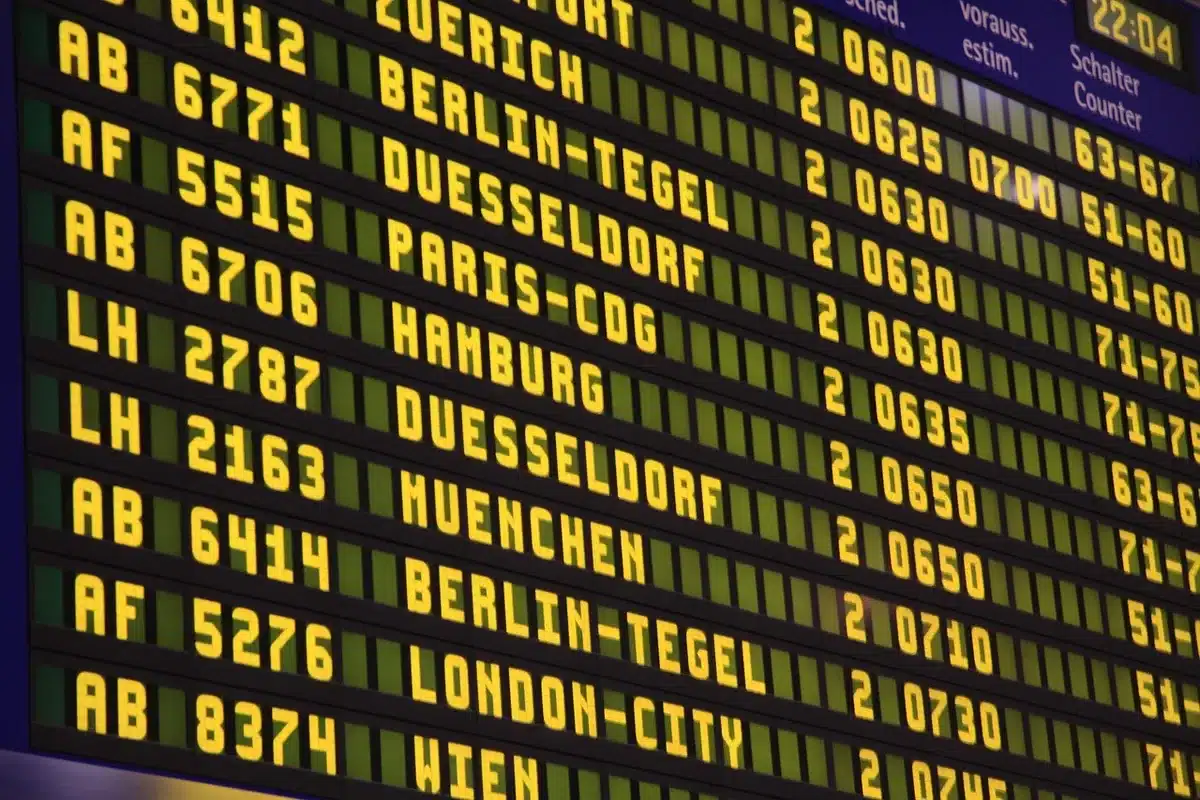 Concourse at an airport with team bags and a departures board, evocative of long travel