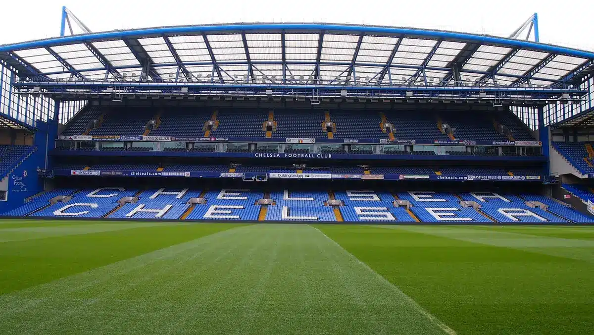 Empty stadium seats with a distant pitch, suggesting uncertainty over fixtures and standings