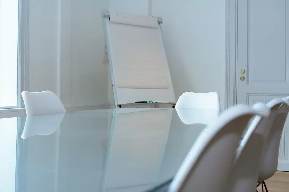 Empty boardroom table with unbranded shirts, briefcase and legal pad in daylight