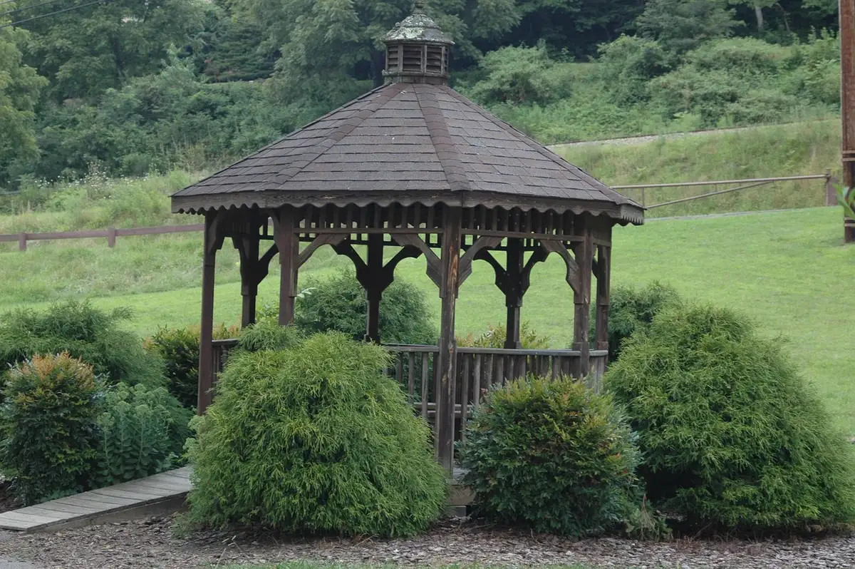 Sixth-grade students tidying a park near a gazebo during a community clean-up