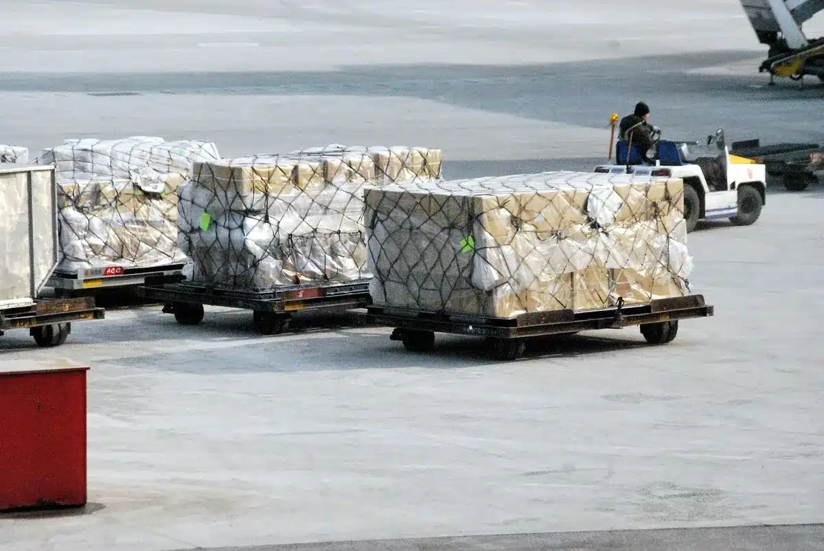 Anonymous hands passing sealed medical supplies box in airport cargo hold